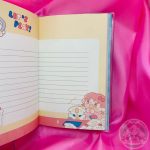 Hoja rayada decorada con dibujo de chica kawaii y perrito.