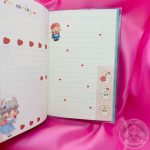 Hoja rayada decorada con imágenes de chicas kawaii, corazones y perritos.