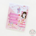 Bloc de notas con fondo de color rosa y blnaco, en la parte inferior derecha se encuentra el dibujo de una chica, parte superior derecha, cerezas, parte inferior izquierda listones y una caja con peluches.