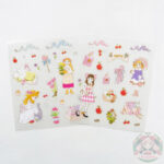 Dos planchas de stickers, ambas tienen dos chicas kawaii, manzanas y cerezas, flores, moños, libro, etc.
